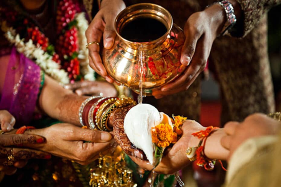 Water poured from a copper vessel over joined hands during a Hindu wedding rite
