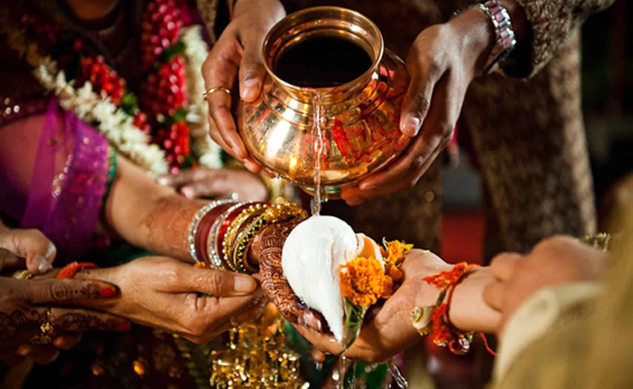Water poured from a copper vessel over joined hands during a Hindu wedding rite