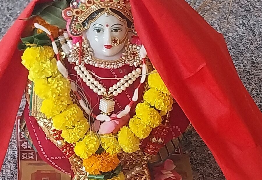 A Devi altar dressed with marigold garlands and offerings for a household puja