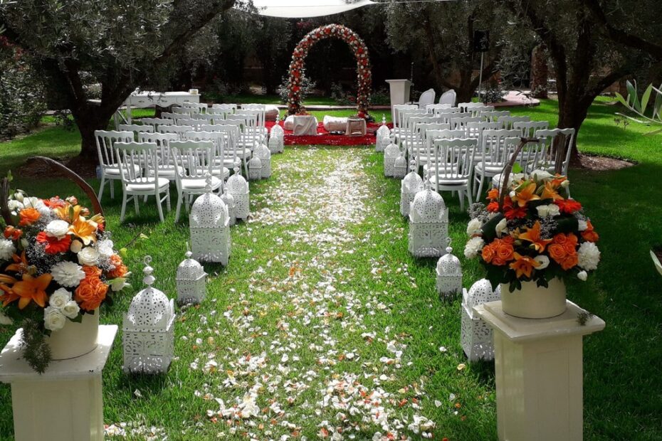 A Hindu wedding ceremony set in a Moroccan garden, with the floral arch and petal-strewn aisle among olive trees