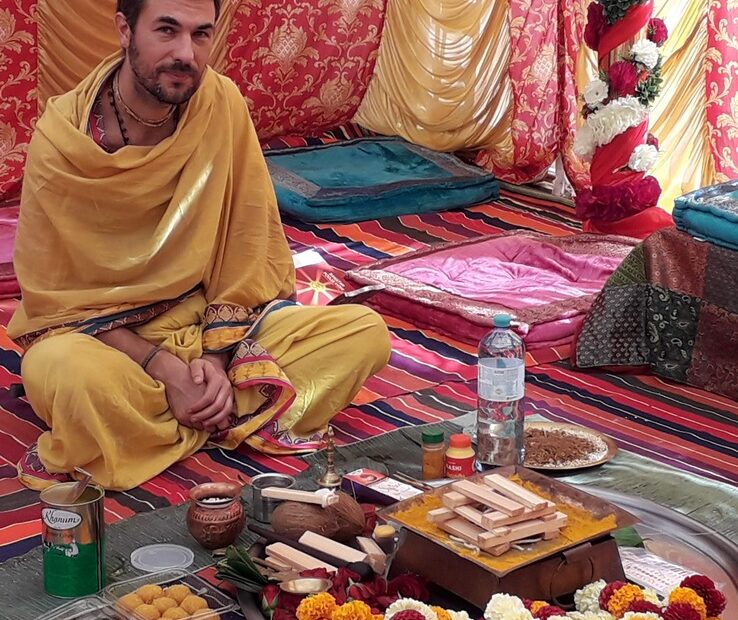 Pandit Sahadev seated before the puja articles during a Vedic ceremony