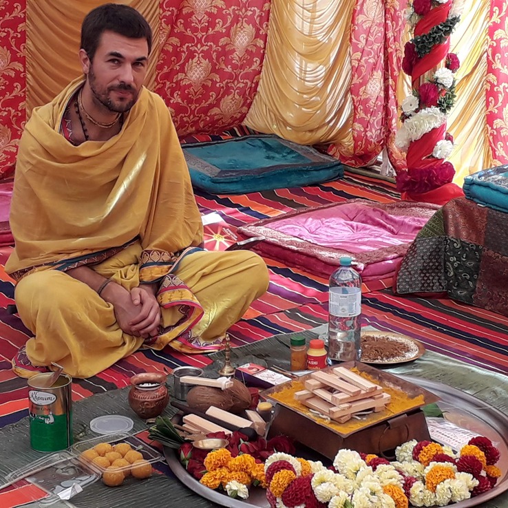 Pandit Sahadev seated before the puja articles during a Vedic ceremony