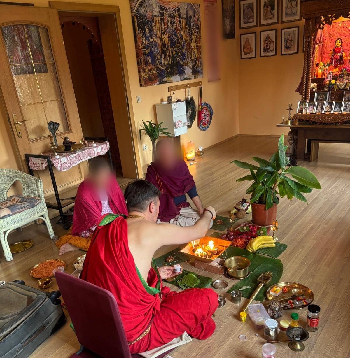 Vedic Homa conducted in Europe, the priest offering into the kindled Agni with fruit, flower and grain set out on banana leaf